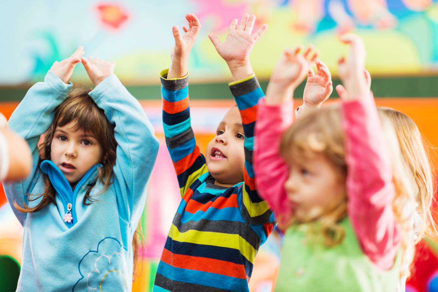 Cute little kids dancing with raised arms